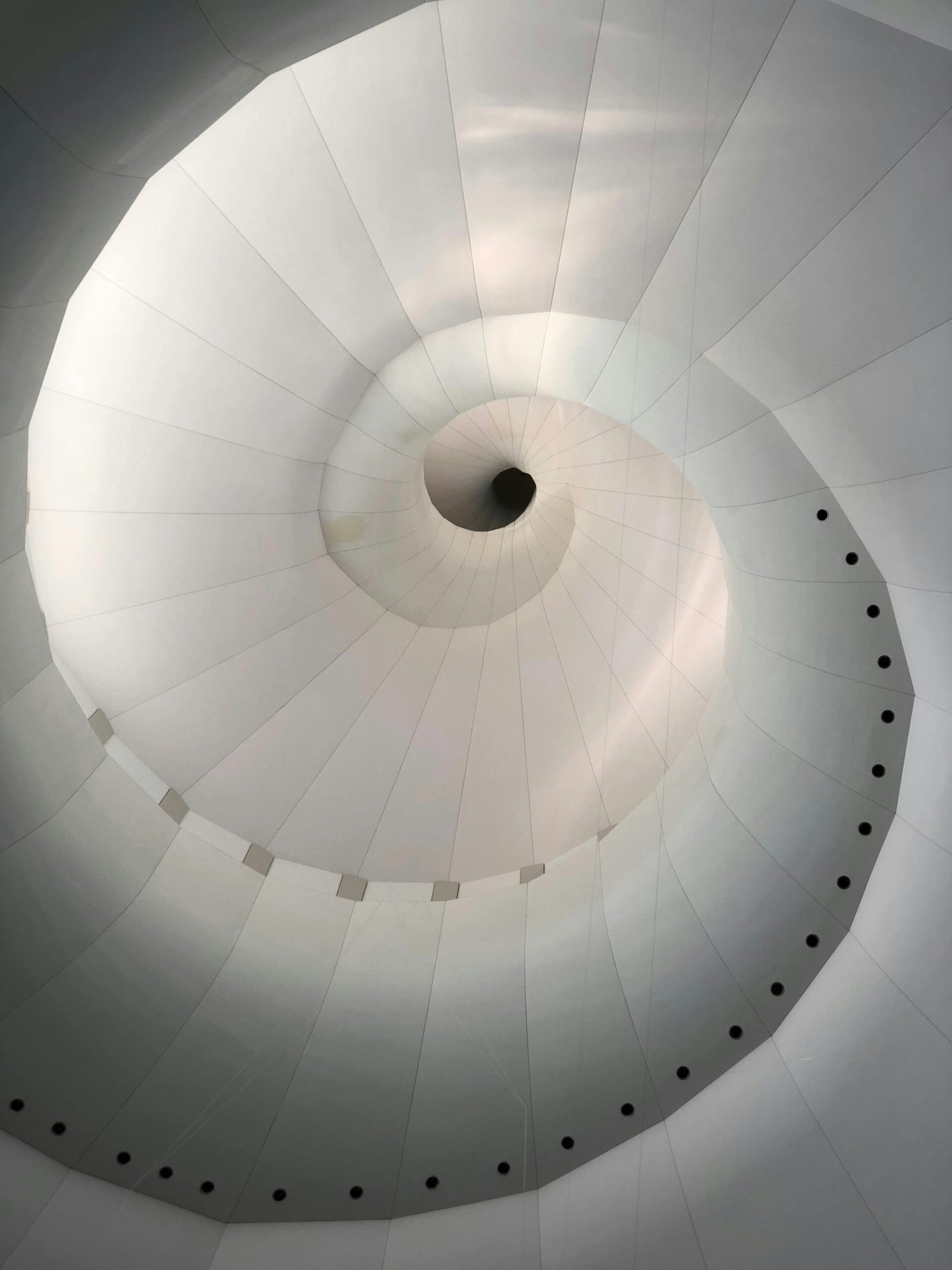 Top view of modern light gray twisting construction with dense texture and geometric lines and small dots on surface