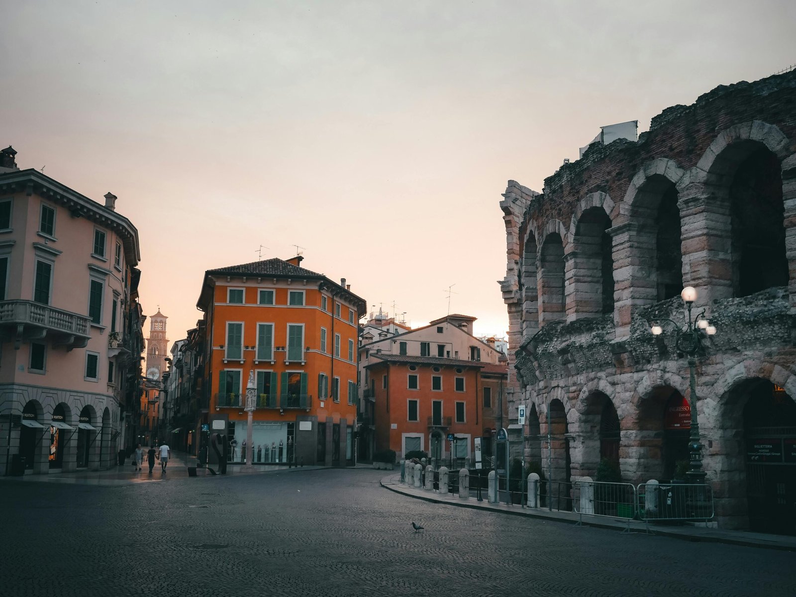 Verona Arena and cityscape at sunset in Verona, Italy, showcasing historic architecture.